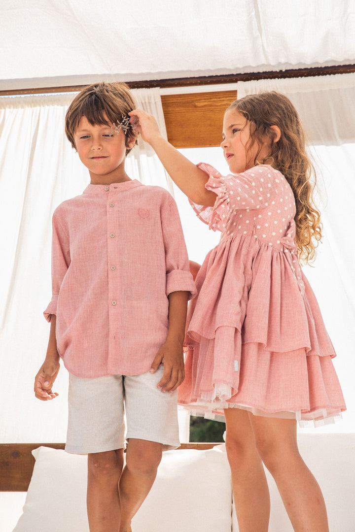 A delicate petal pink woven dress from the Tutto Piccolo baby girl collection, embodying elegance and comfort, ideal for special occasions or stylish everyday wear.